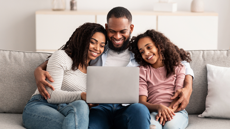 family sitting on couch looking at computer