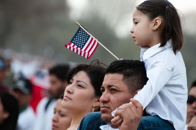 immigrant family holding american flag