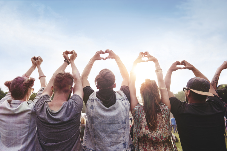 group of people holding up heart hands