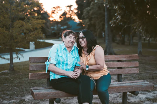 women giggling on a bench