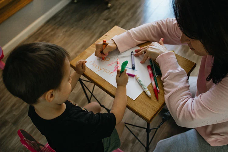 mom and son writing on paper