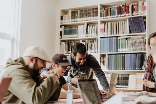 group of happy people looking at computers