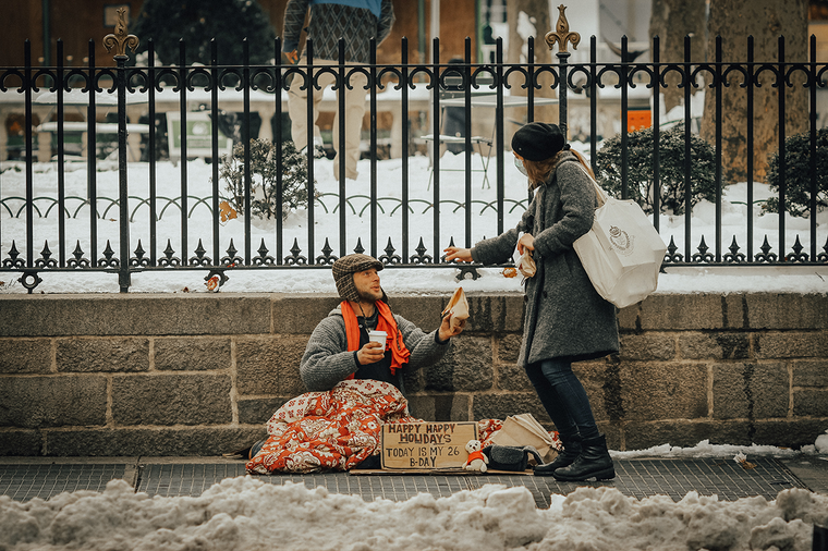 woman giving homeless man food