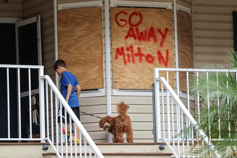 boarded up house of boy with dog and sign that says go away milton