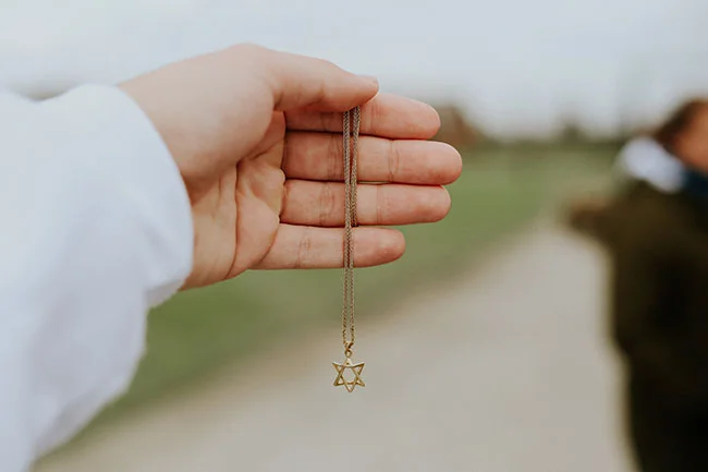 hand holding jewish star necklace