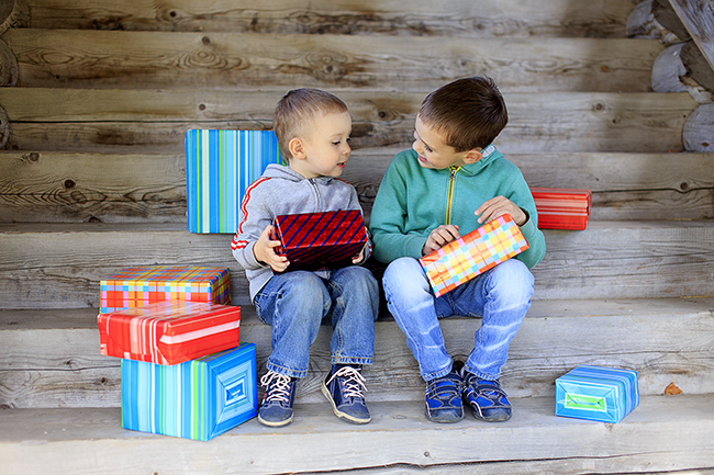 two kids holding wrapped gifts