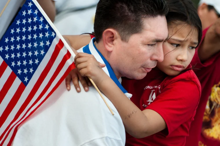 man holding girl who is holding an american flag